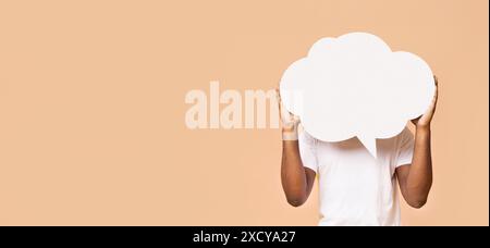 Persona che tiene una bolla di discorso vuota davanti al viso Foto Stock