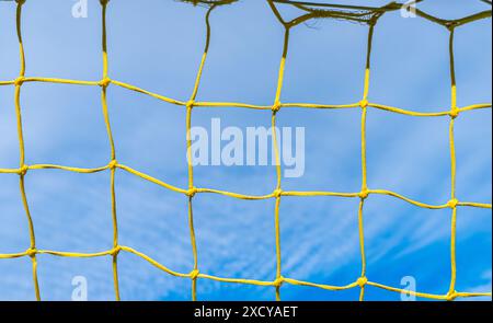 rete di un gol da calcio giallo con cielo blu sullo sfondo Foto Stock