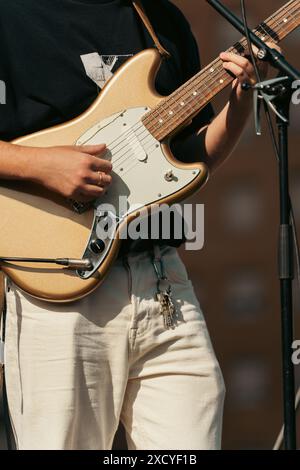 Taglio di un giovane che suona la chitarra ad un concerto rock. Verticale Foto Stock
