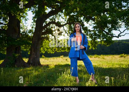 Bella judoka ispanica con cintura nera che si allena nel bosco Foto Stock