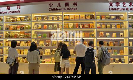 Pechino, Cina. 19 giugno 2024. La gente visita la 30a Fiera Internazionale del Libro di Pechino a Pechino, capitale della Cina, 19 giugno 2024. La 30a Fiera Internazionale del Libro di Pechino ha avuto inizio a Pechino mercoledì, attirando una più ampia partecipazione di espositori stranieri rispetto allo scorso anno. Con un'area espositiva ampliata di 55.000 metri quadrati quest'anno, l'evento di cinque giorni ha riunito circa 1.600 espositori provenienti da 71 paesi e regioni, presentando 220.000 pubblicazioni cinesi e straniere ai visitatori, secondo gli organizzatori. Crediti: Li Xin/Xinhua/Alamy Live News Foto Stock