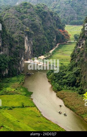 Vista mozzafiato dei sampan turistici che si snodano lungo il fiume Tam Coc, presa dallo spettacolare punto di osservazione della montagna a 500 gradini, Ninh Bình, Vietnam Foto Stock