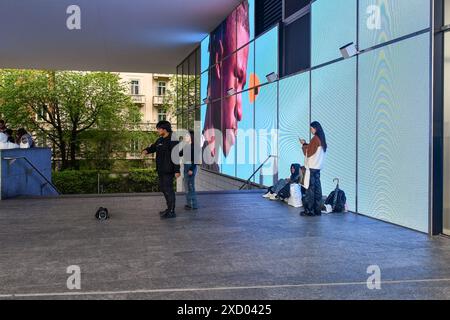 Un piccolo gruppo di adolescenti che cercano una danza da condividere su TikTok in Piazza Gae Aulenti, quartiere porta Garibaldi, Milano, Lombardia, Italia Foto Stock