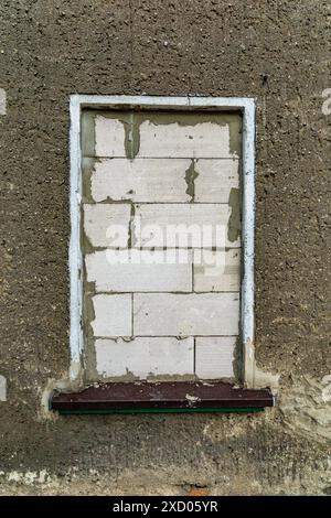 Concetto di sfratto di mattoni su finestre su pareti in cemento Foto Stock