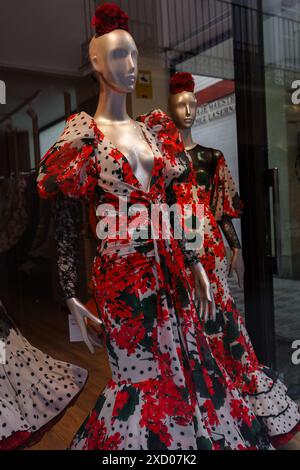 Siviglia, Spagna. 4 febbraio 2024 - manichini con abiti di flamenco rossi in vetrina Foto Stock