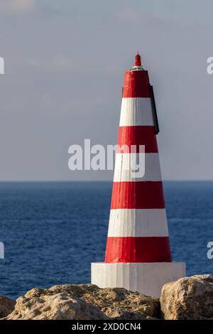 faro sulla costa del mare di Mgarr Port, Gozo Foto Stock