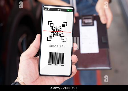Una persona ha in mano un telefono con la scritta "scansione". Sono anche in possesso di una ricevuta, di una mano femminile che tiene un telefono cellulare nero con codice qr sul dispositivo sc Foto Stock