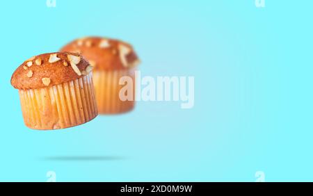 Muffin alle mandorle isolati su sfondo blu con spazio per il testo. Foto Stock