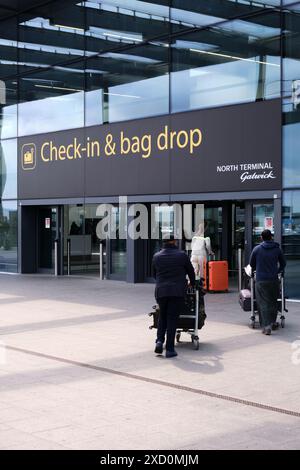 Aeroporto di Gatwick, Londra, Regno Unito: 22 aprile 2024. I passeggeri con carrello bagagli si avvicinano all'ingresso per effettuare il check-in e il ritiro bagagli. Foto Stock