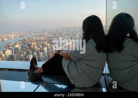 New York, Stati Uniti. 18 giugno 2024. Una donna sta guardando la vista dall'alto di New York dalla piattaforma di osservazione Summit One Vanderbilt a New York, Stati Uniti, il 18 giugno 2024. L'attrazione porta i visitatori al 93° piano, sopra iconici grattacieli come l'Empire State Building e il Chrysler Building. One Vanderbilt si erge come un grattacielo all'angolo tra la 42nd Street e Vanderbilt Avenue nel quartiere Midtown Manhattan di New York City. (Foto di Aashish Kiphayet/NurPhoto) crediti: NurPhoto SRL/Alamy Live News Foto Stock