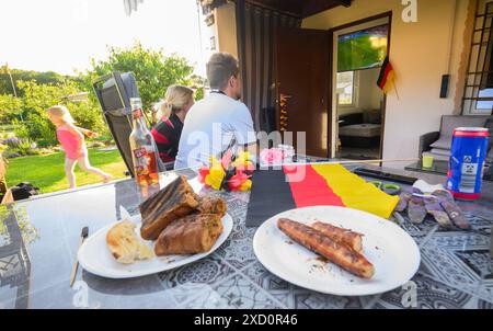 Gelsenkirchen, Germania. 19 giugno 2024. Calcio, UEFA Euro 2024, Germania - Ungheria, turno preliminare, gruppo A, giorno della partita 2. Una famiglia guarda la partita in televisione nel suo giardino di allotment nell'associazione Gelsenpark. Credito: Julian Stratenschulte/dpa/Alamy Live News Foto Stock