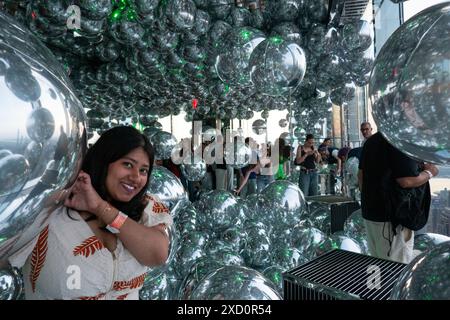 Una donna sta potendo per una fotografia presso ''Affinity'' al Summit One Vanderbilt Observation deck di New York, negli Stati Uniti, il 18 giugno 2024. Il Summit One Vanderbilt è un vero e proprio paese delle meraviglie di esperienze sensoriali. Kenzo Digital, l'artista che sta progettando ogni stanza, sta usando degli specchi per riflettere e rifrangere la città che circonda la struttura. L'attrazione porta i visitatori al 93° piano, sopra iconici grattacieli come l'Empire State Building e il Chrysler Building. (Foto di Aashish Kiphayet/NurPhoto) Foto Stock