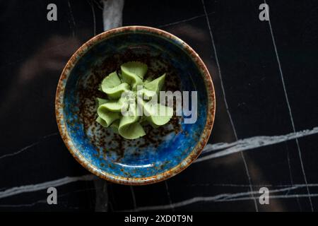 Vista dall'alto di una ciotola in ceramica di Wasabi, condimento tipico dell'Asia orientale. Foto Stock