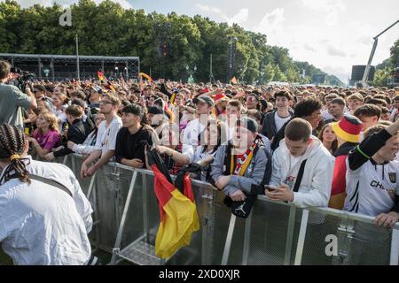 Berlino, Germania 19 giugno 2024, Berlino, Germania: Mentre la Germania affrontava l'Ungheria nell'odierna partita UEFA EURO 2024 del 19 giugno 2024, migliaia di tifosi si sono riuniti nelle iconiche zone dei tifosi all'edificio del Reichstag e alla porta di Brandeburgo per tifare la propria squadra nazionale. La folla vibrante, sventolando bandiere tedesche e cantando all'unisono, ha creato un'atmosfera festosa che esemplificava la passione e il sostegno dei tifosi di calcio tedeschi. Il Campionato europeo UEFA 2024, ufficialmente noto come UEFA EURO 2024, è la diciassettesima edizione del torneo ed è ospitato dalla Germania dal 14 giugno al 14 luglio. Crediti: ZUMA Press, Inc./Ala Foto Stock