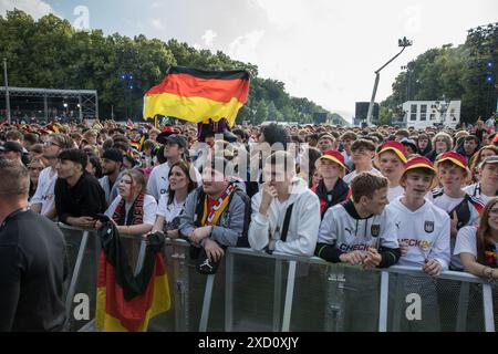 Berlino, Germania 19 giugno 2024, Berlino, Germania: Mentre la Germania affrontava l'Ungheria nell'odierna partita UEFA EURO 2024 del 19 giugno 2024, migliaia di tifosi si sono riuniti nelle iconiche zone dei tifosi all'edificio del Reichstag e alla porta di Brandeburgo per tifare la propria squadra nazionale. La folla vibrante, sventolando bandiere tedesche e cantando all'unisono, ha creato un'atmosfera festosa che esemplificava la passione e il sostegno dei tifosi di calcio tedeschi. Il Campionato europeo UEFA 2024, ufficialmente noto come UEFA EURO 2024, è la diciassettesima edizione del torneo ed è ospitato dalla Germania dal 14 giugno al 14 luglio. Crediti: ZUMA Press, Inc./Ala Foto Stock