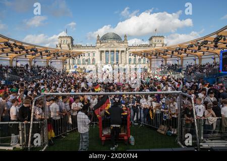 Berlino, Germania 19 giugno 2024, Berlino, Germania: Mentre la Germania affrontava l'Ungheria nell'odierna partita UEFA EURO 2024 del 19 giugno 2024, migliaia di tifosi si sono riuniti nelle iconiche zone dei tifosi all'edificio del Reichstag e alla porta di Brandeburgo per tifare la propria squadra nazionale. La folla vibrante, sventolando bandiere tedesche e cantando all'unisono, ha creato un'atmosfera festosa che esemplificava la passione e il sostegno dei tifosi di calcio tedeschi. Il Campionato europeo UEFA 2024, ufficialmente noto come UEFA EURO 2024, è la diciassettesima edizione del torneo ed è ospitato dalla Germania dal 14 giugno al 14 luglio. Crediti: ZUMA Press, Inc./Ala Foto Stock