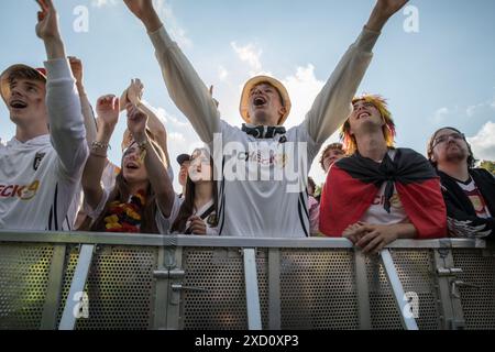 Berlino, Germania 19 giugno 2024, Berlino, Germania: Mentre la Germania affrontava l'Ungheria nell'odierna partita UEFA EURO 2024 del 19 giugno 2024, migliaia di tifosi si sono riuniti nelle iconiche zone dei tifosi all'edificio del Reichstag e alla porta di Brandeburgo per tifare la propria squadra nazionale. La folla vibrante, sventolando bandiere tedesche e cantando all'unisono, ha creato un'atmosfera festosa che esemplificava la passione e il sostegno dei tifosi di calcio tedeschi. Il Campionato europeo UEFA 2024, ufficialmente noto come UEFA EURO 2024, è la diciassettesima edizione del torneo ed è ospitato dalla Germania dal 14 giugno al 14 luglio. Crediti: ZUMA Press, Inc./Ala Foto Stock