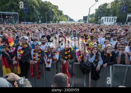 Mentre la Germania affrontava l'Ungheria nell'odierna partita UEFA EURO 2024 il 19 giugno 2024, migliaia di tifosi si sono riuniti nelle iconiche zone dei tifosi presso l'edificio del Reichstag e la porta di Brandeburgo per tifare la propria squadra nazionale. La folla vibrante, sventolando bandiere tedesche e cantando all'unisono, ha creato un'atmosfera festosa che esemplificava la passione e il sostegno dei tifosi di calcio tedeschi. Il Campionato europeo UEFA 2024, ufficialmente noto come UEFA EURO 2024, è la diciassettesima edizione del torneo ed è ospitato dalla Germania dal 14 giugno al 14 luglio. Al Reichstag, la sede del parlamento tedesco, un mare di nero, rosso, A. Foto Stock