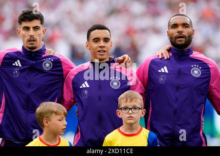 (Da sinistra a destra) il tedesco Kai Havertz, il tedesco Jamal Musiala e il tedesco Jonathan Tah durante l'inno nazionale della loro squadra prima della partita UEFA Euro 2024 del gruppo A alla Stuttgart Arena di Stoccarda, Germania. Data foto: Mercoledì 19 giugno 2024. Foto Stock