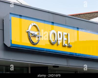 Cartello con il logo Opel in un edificio di un concessionario di auto. Emblema su sfondo giallo del costruttore. Punto di assistenza del marchio automobilistico tedesco. Foto Stock