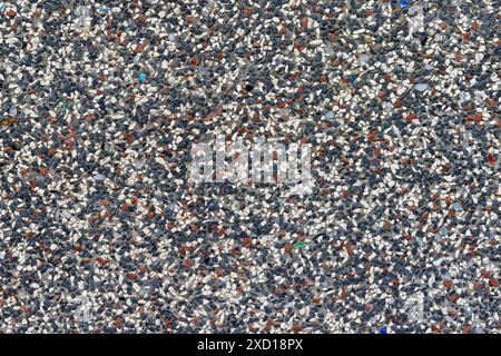 vista ravvicinata dello sfondo di un'area di intonaco colorata, composta da pietre bianche, blu scuro e rosse con disposizione casuale Foto Stock