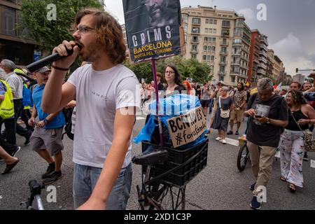 Barcellona, Spagna. 19 giugno 2024. Un manifestante si vede urlare slogan con un microfono durante la dimostrazione. Migliaia di persone si sono riunite in via Aragón per protestare contro la mostra automobilistica di Formula 1 e il fan Festival nel centro della città, che ha causato ingorghi e inquinamento atmosferico enormi. I manifestanti chiedono che la città non debba essere venduta a grandi marchi commerciali elitari. Credito: SOPA Images Limited/Alamy Live News Foto Stock