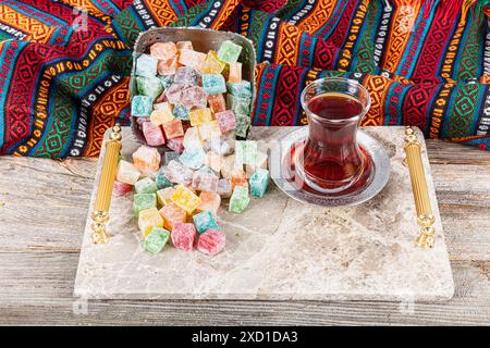 Delizie turche assortite su un vassoio di rame con un bicchiere di tè. Molte delizie turche dolci colorate in una tradizionale ciotola argentata per le vacanze. l Foto Stock