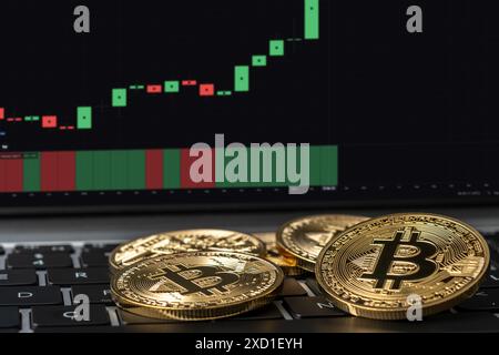 Moneta d'oro Bitcoin e sfondo grafico di trading. Concetto di criptovaluta virtuale. Foto Stock