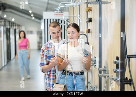 Una coppia positiva ha scelto la doccia nel negozio di articoli per il bagno Foto Stock