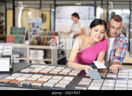 Accoppiare i campioni di piastrelle di navigazione sulla bacheca nel negozio di articoli per il miglioramento della casa Foto Stock