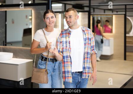 Una coppia interessata a esplorare le attrezzature per il bagno in un negozio di articoli per la casa Foto Stock