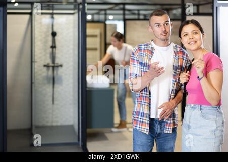 Una simpatica coppia interrazziale in cerca di accessori per il bagno nello showroom Foto Stock