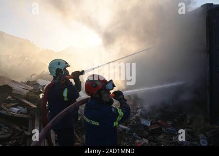 Scoppia un incendio a Koropi, vicino ad Atene, i vigili del fuoco scaricano l'acqua per estinguere l'incendio in un container a Koropi vicino ad Atene. Atene Grecia Copyright: XNicolasxKoutsokostasxNicolasxKoutsokostasx DSC 202406190437 Foto Stock