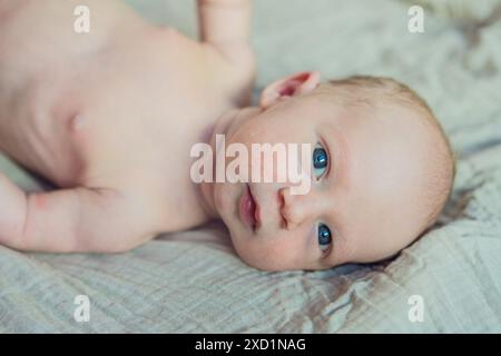 La pelle del neonato si sta staccando. La mamma utilizza prodotti per la pelle e massaggi per curare e lenire la delicata pelle del bambino, garantendo comfort e promozione Foto Stock