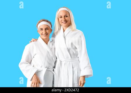 Donne mature in accappatoi su sfondo blu Foto Stock