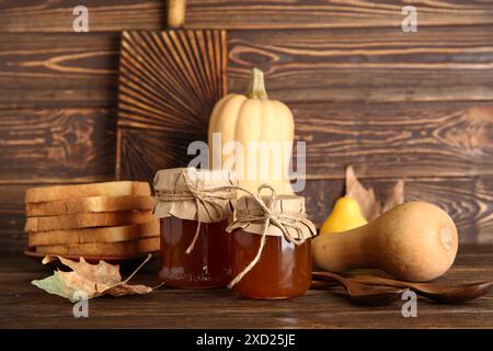 Barattoli di marmellata dolce di zucca e toast su fondo di legno Foto Stock