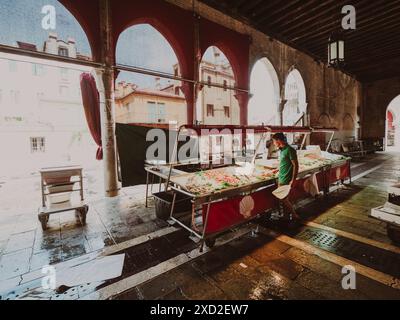 Venezia, Italia - 20 giugno 2021 Fishmonger in un tradizionale mercato veneziano, preparando pesce fresco al loro banco Foto Stock