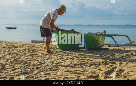 Balikpapan, Indonesia - 16 aprile 2024. Sta indossando un berretto e controllando la rete prima di andare in mare. Foto Stock