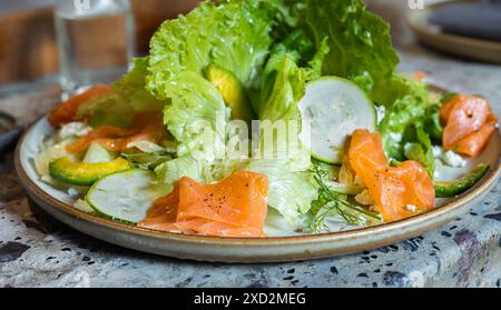 Insalata di salmone. Salmone affumicato con avocado e mescolare le verdure su un piatto. Insalata di salmone affumicato verde Goddess. Mangiare sano. Insalata verde con salmone. Foto Stock