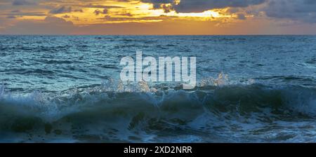 Tramonto incredibile dalla spiaggia della Thailandia. Tramonto con spiaggia sabbiosa con onde. Spettacolare tramonto sul cielo su una spiaggia di sabbia in Thailandia. Nuvole tempestose sulla spiaggia Foto Stock