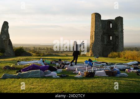 Hadleigh Essex, Regno Unito. 20 giugno 2024. Una lezione di Yoga nei terreni del Castello di Hadleigh nell'Essex nel Regno Unito saluta l'alba la mattina del solstizio d'estate. Il sole sorge alle 04:40 e tramonta alle 21:19 in quello che è il giorno più lungo dell'anno. Il periodo ufficiale del solstizio d'estate nel Regno Unito è alle 21:50 del 20 giugno 2024. Crediti: MARTIN DALTON/Alamy Live News Foto Stock