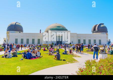 Los Angeles, California - 8 aprile 2024: Le persone si riuniscono per osservare un'eclissi solare al Griffith Park, con lo storico osservatorio Griffith alle spalle Foto Stock