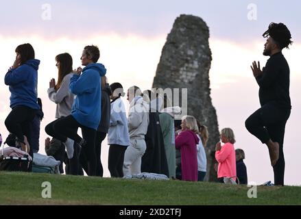 Hadleigh Essex, Regno Unito. 20 giugno 2024. Una lezione di Yoga nei terreni del Castello di Hadleigh nell'Essex nel Regno Unito saluta l'alba la mattina del solstizio d'estate. Il sole sorge alle 04:40 e tramonta alle 21:19 in quello che è il giorno più lungo dell'anno. Il periodo ufficiale del solstizio d'estate nel Regno Unito è alle 21:50 del 20 giugno 2024. Crediti: MARTIN DALTON/Alamy Live News Foto Stock