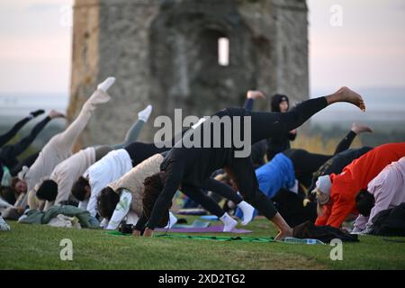 Hadleigh Essex, Regno Unito. 20 giugno 2024. Una lezione di Yoga nei terreni del Castello di Hadleigh nell'Essex nel Regno Unito saluta l'alba la mattina del solstizio d'estate. Il sole sorge alle 04:40 e tramonta alle 21:19 in quello che è il giorno più lungo dell'anno. Il periodo ufficiale del solstizio d'estate nel Regno Unito è alle 21:50 del 20 giugno 2024. Crediti: MARTIN DALTON/Alamy Live News Foto Stock