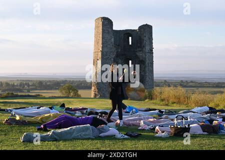 Hadleigh Essex, Regno Unito. 20 giugno 2024. Una lezione di Yoga nei terreni del Castello di Hadleigh nell'Essex nel Regno Unito saluta l'alba la mattina del solstizio d'estate. Il sole sorge alle 04:40 e tramonta alle 21:19 in quello che è il giorno più lungo dell'anno. Il periodo ufficiale del solstizio d'estate nel Regno Unito è alle 21:50 del 20 giugno 2024. Crediti: MARTIN DALTON/Alamy Live News Foto Stock