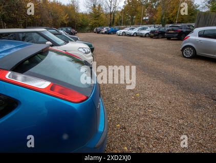 Un parcheggio della stazione ferroviaria nel Suffolk rurale è stato ampliato estendendosi a quello che doveva essere il giardino del padrone della stazione e presto le auto lo riempirono. Foto Stock