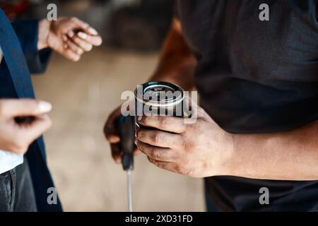 Mani, meccanici e persone con filtro carburante, lavoro di squadra e officina di riparazione auto con assistenza, garage e competenze. Parte del veicolo, primo piano e dipendenti con Foto Stock