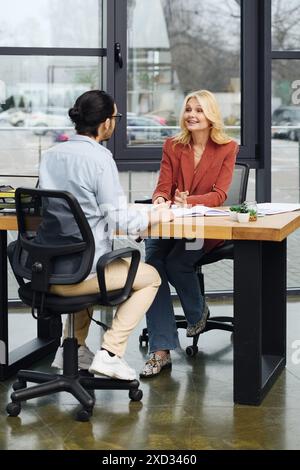 Una donna attraente è impegnata in una conversazione con un uomo durante un colloquio di lavoro. Foto Stock