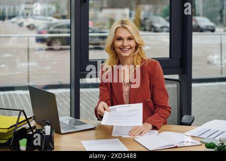 Una donna immersa nel lavoro su una scrivania ingombrante con i documenti. Foto Stock