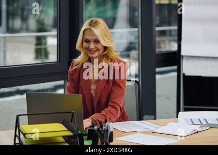 Una donna lavora su un notebook a una scrivania. Foto Stock